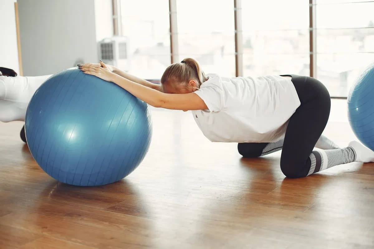 Hamile pilatesi — hamile kadının pilates topuyla yaptığı nazik germe egzersizi